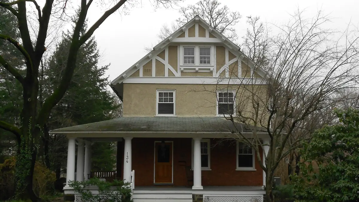 Two-storey house with a brick ground floor and a wide covered front porch