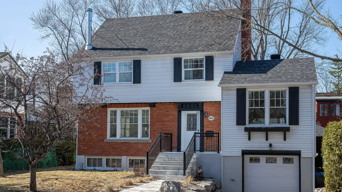 Two-storey house with white siding, a brick ground floor and an attached garage